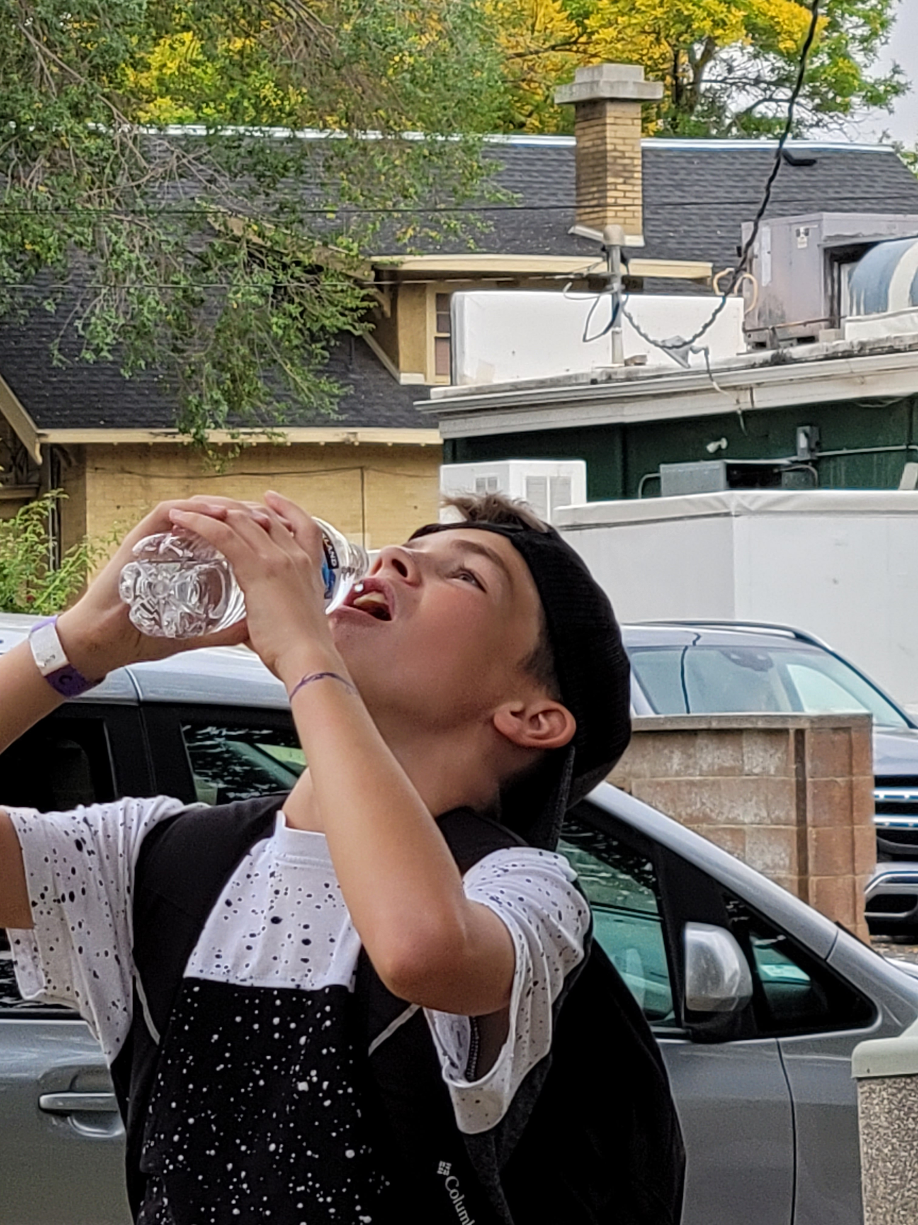 A student takes a drink during a walking field trip