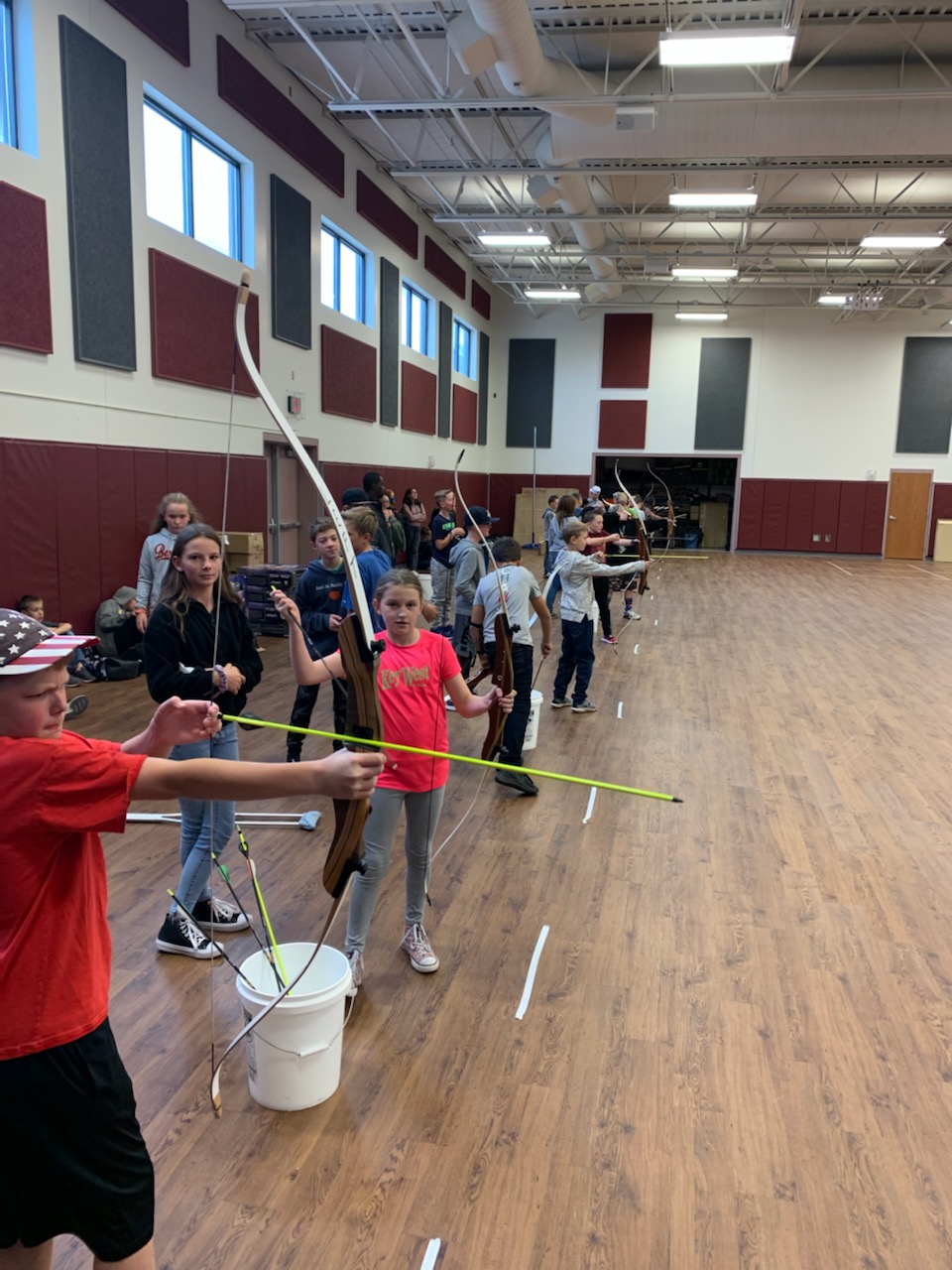Students prepare to launch their arrows toward the targets.