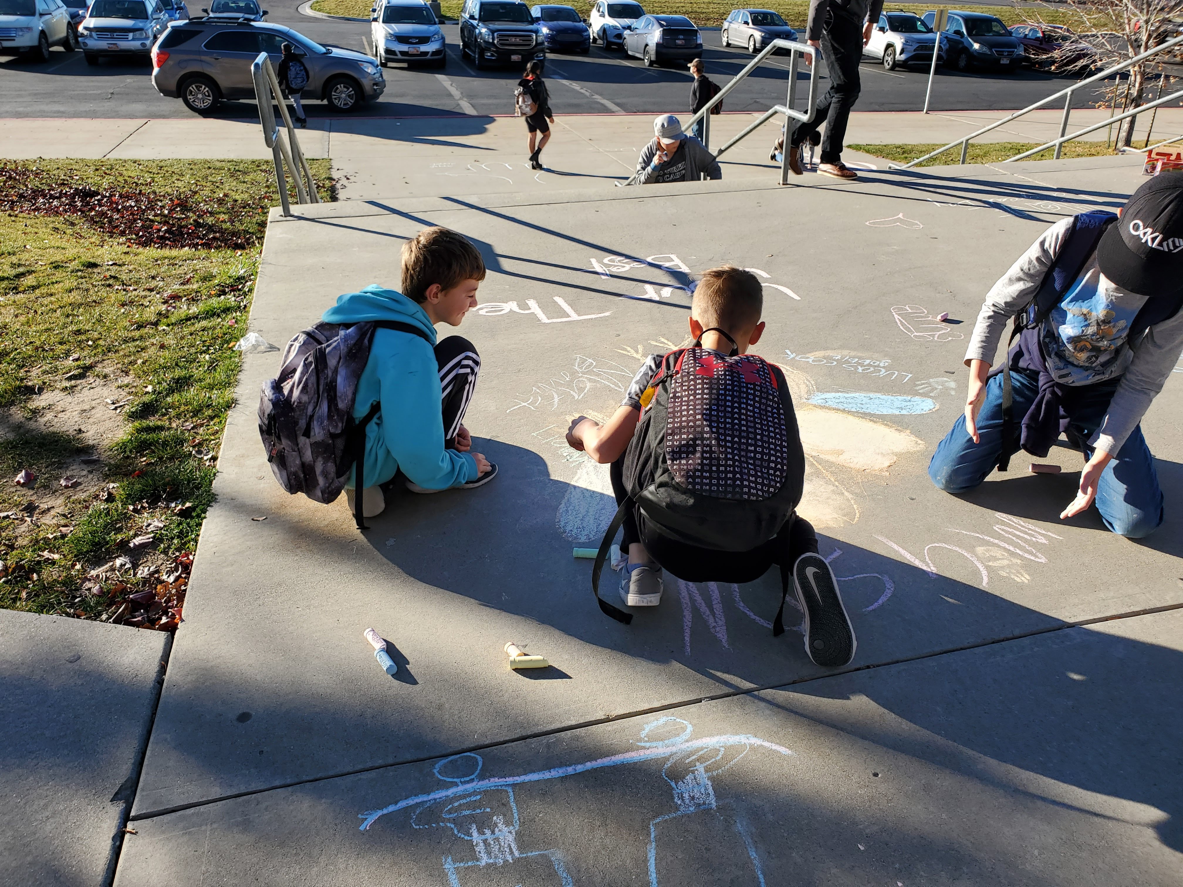 Students create chalk messages on the front steps at DFMS