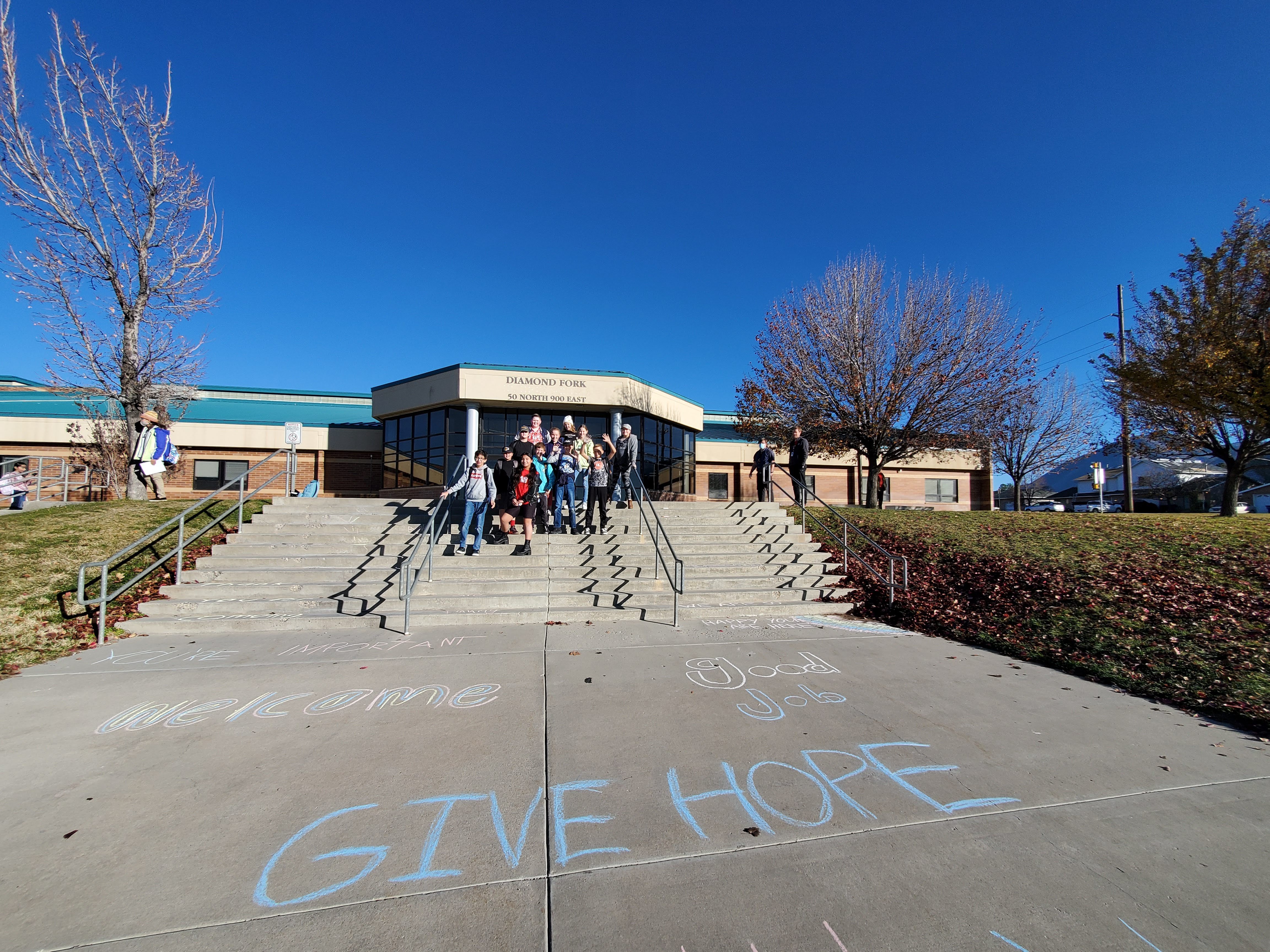 Students create chalk messages on the front steps at DFMS
