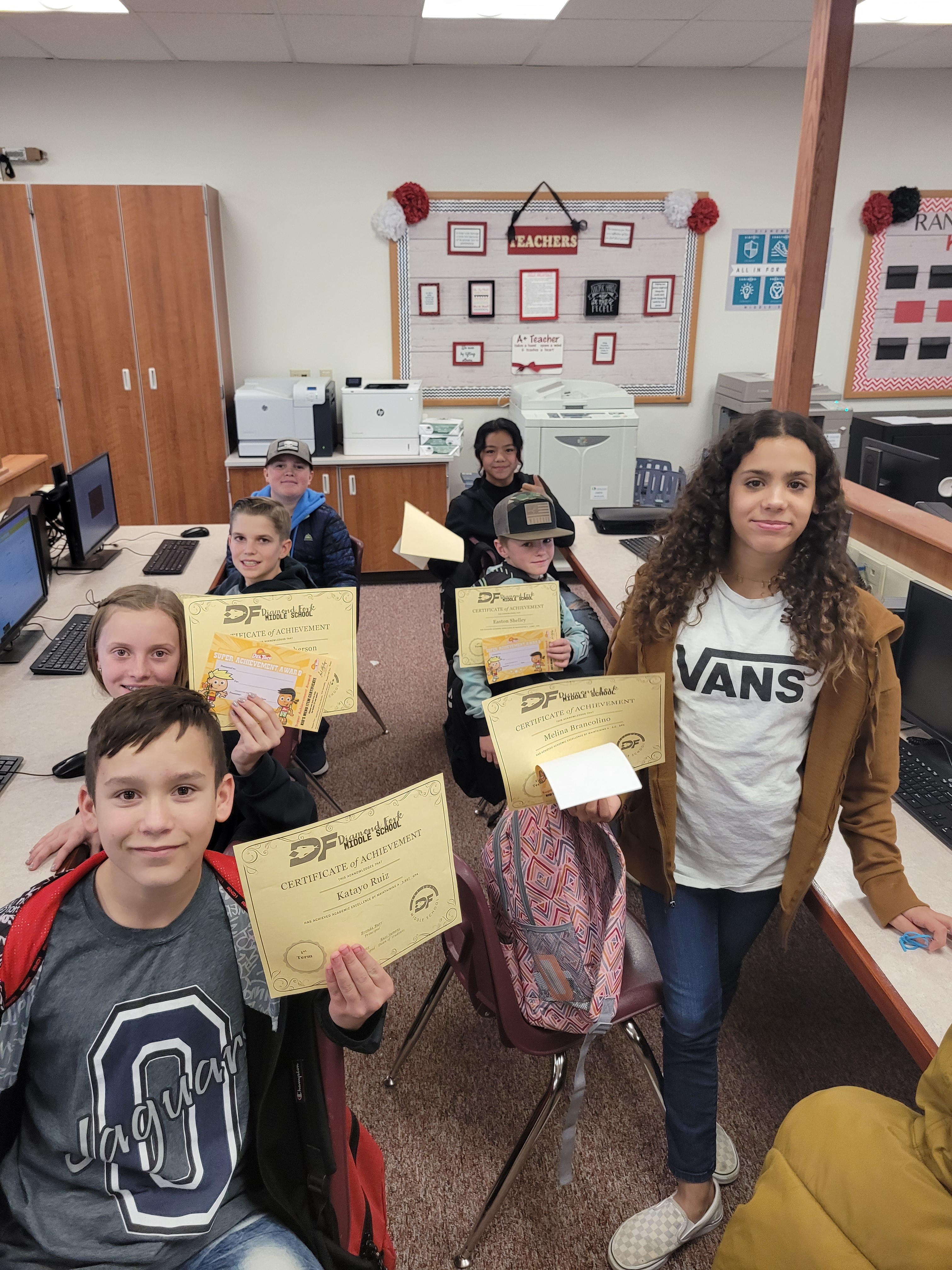 Students showing their honor roll certificates