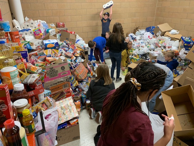 Students sort piles of donated food