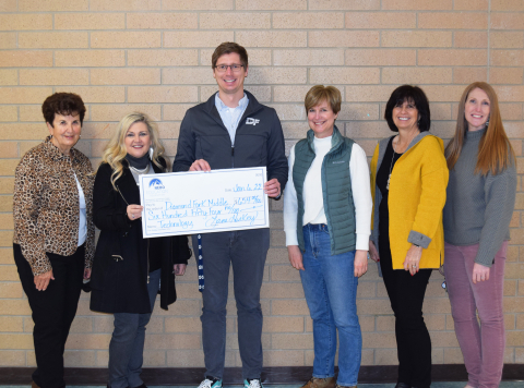 teacher holding large paper check with Nebo Foundation members