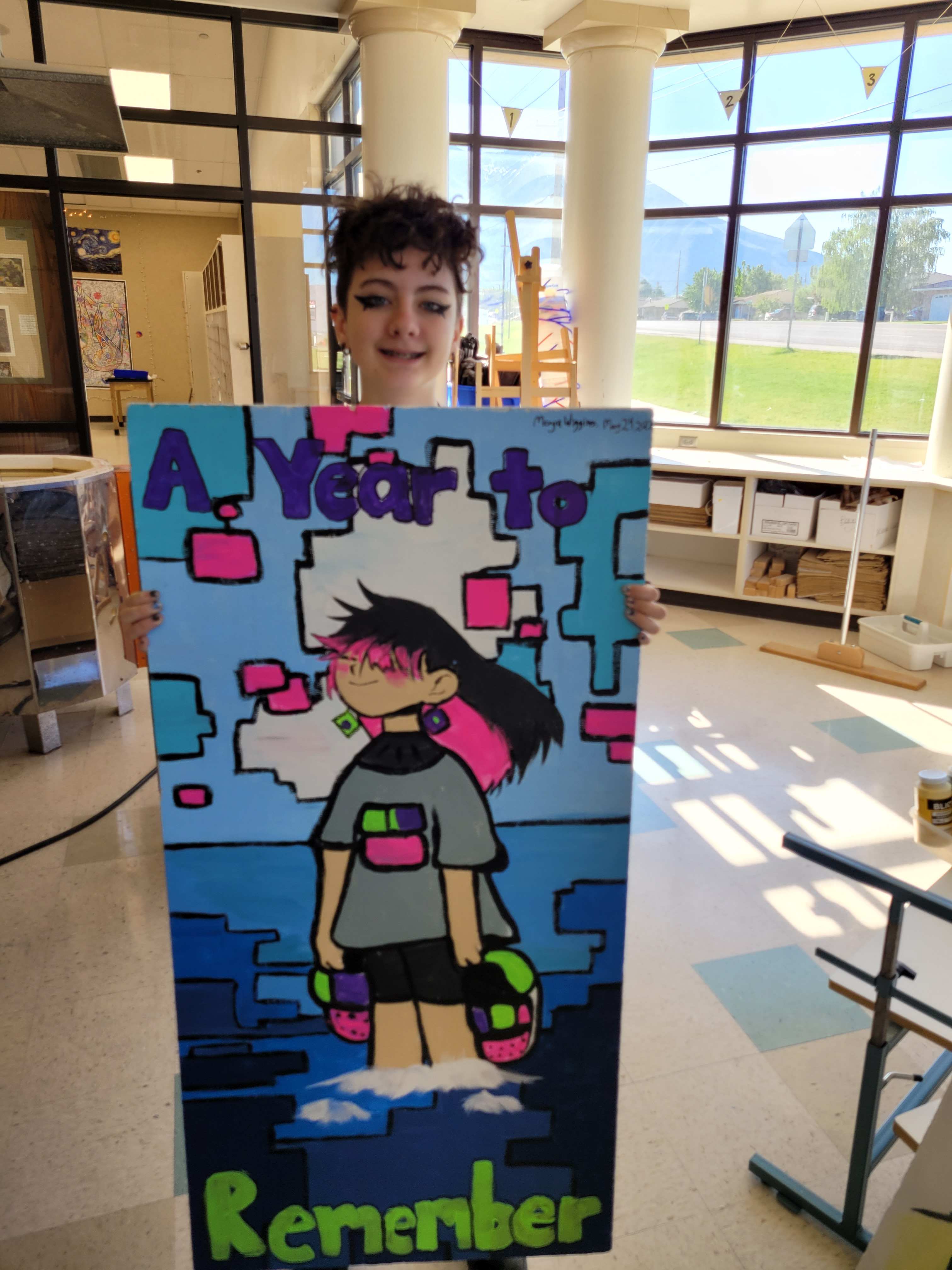 A student holding her ceiling tile art