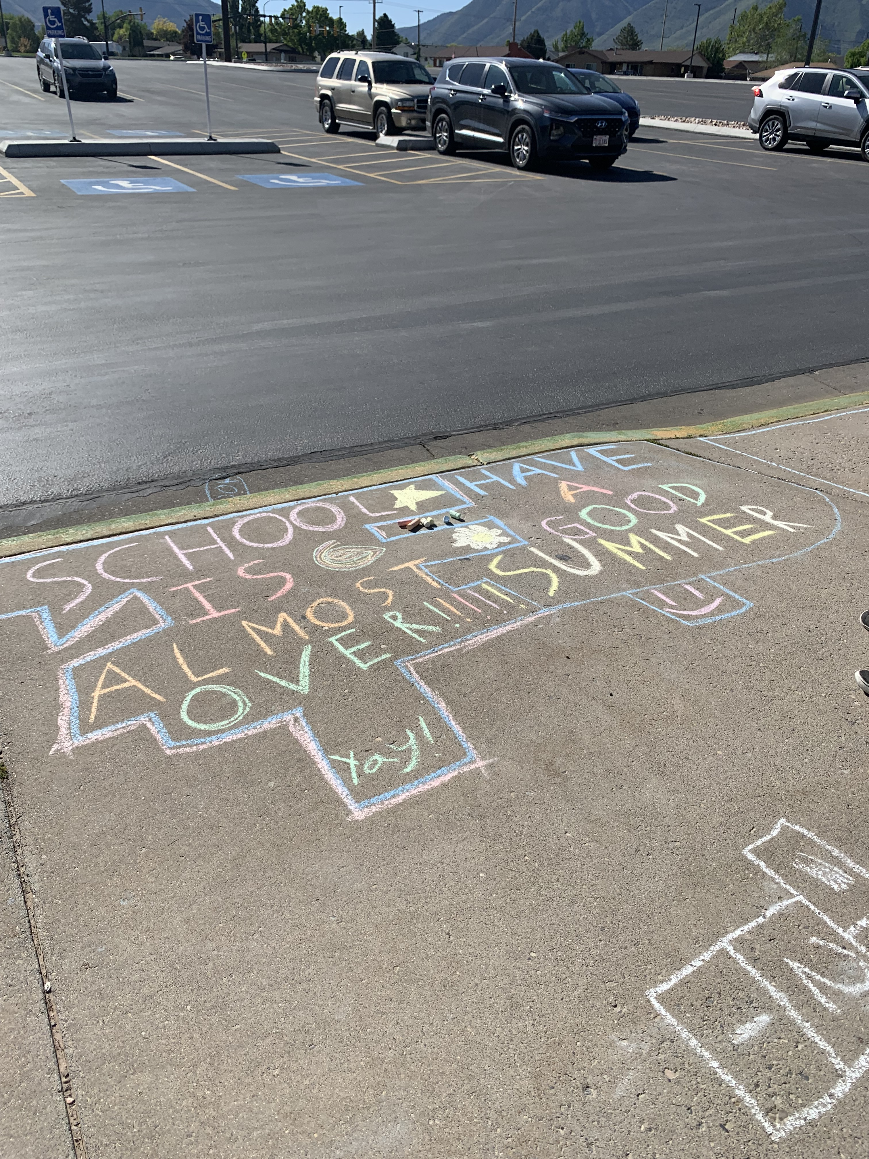 Students writing with chalk on the sidewalks