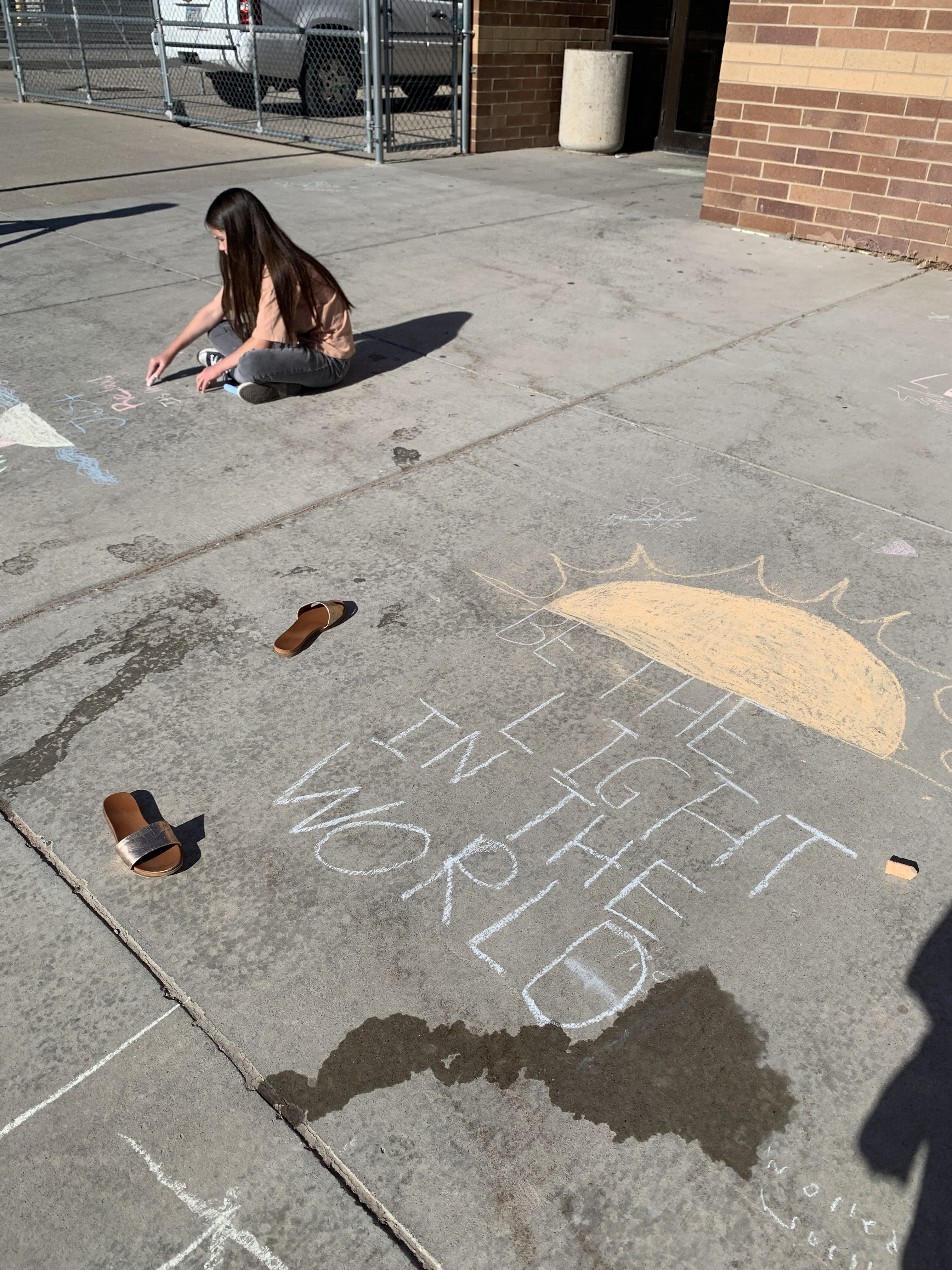 Students writing with chalk on the sidewalks
