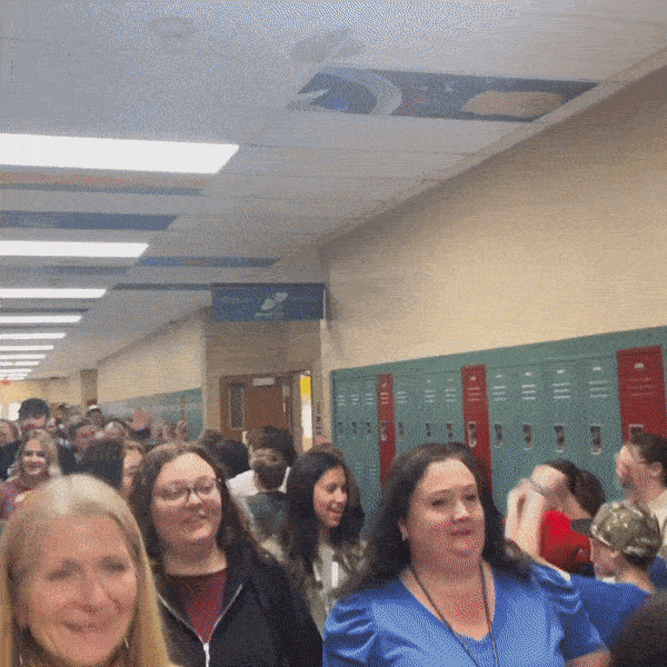 Teachers going through the halls while students cheer