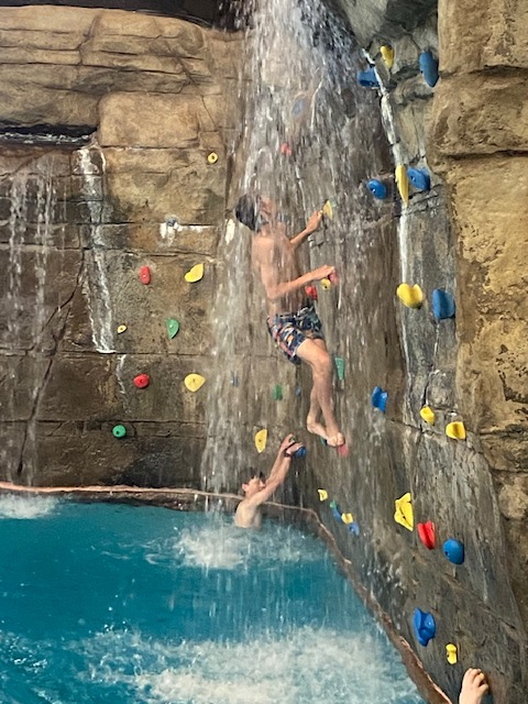 Boys climbing water rock wall