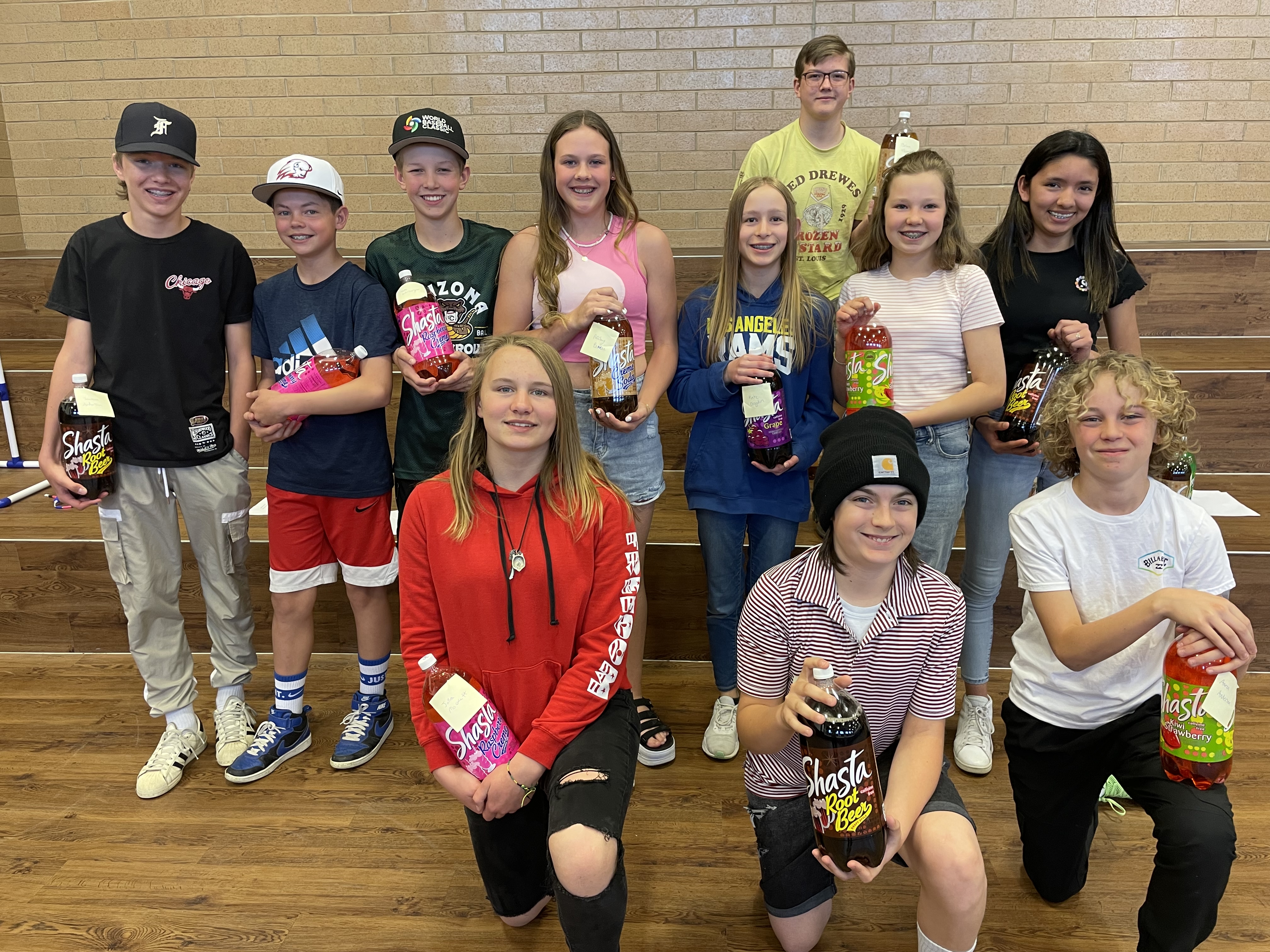 Students who participated in poetry slam holding pop prizes