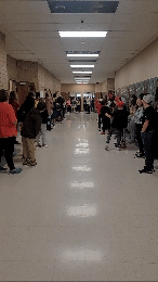 Students lined up in the hallways to cheer for teacher. 