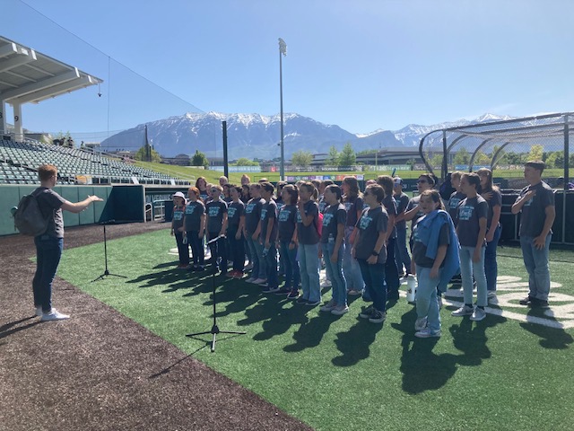 Concert choir singing on UVU's baseball field